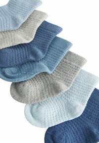 Ett set av stickade strumpor i varierande nyanser av blått och grått, med ribbad mudd och texturerade mönster över materialet.