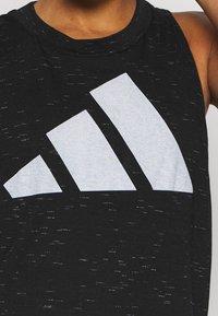 Canotta sportiva nera senza maniche realizzata in tessuto texturizzato, con un grande logo grigio Adidas in design a tre strisce sul davanti.