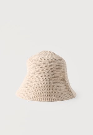 Chapeau bob beige crocheté avec un large bord souple et un motif de points texturé.