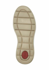 Sole in gomma di un colore beige chiaro con un motivo di grip testurizzato e un accento circolare rosso con l'etichetta "Tamara's Comfort." Bordo bianco lungo il perimetro.