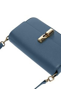 Pochette en cuir bleu avec une finition texturée, dotée d'un fermoir en métal doré et d'une chaîne. Forme rectangulaire compacte, design minimaliste.