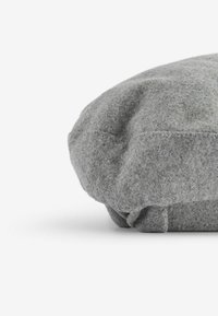 Šedá čepice z jemného materiálu, zaobleného tvaru, s viditelnými švy. Tkanina má mírně melírovaný vzhled.