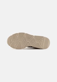 Beige Schuhsohle mit strukturierten Oberflächen, die hexagonale und diamantartige Muster für Grip und Unterstützung aufweist, abgerundete Spitze und flachen Absatz.