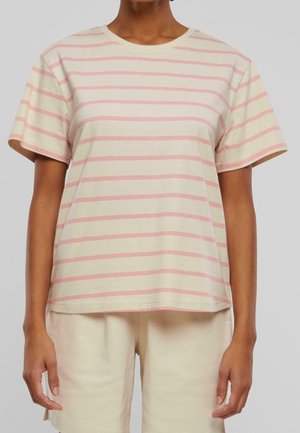 Personne portant un t-shirt beige à manches courtes avec des rayures horizontales roses et un short beige assorti sur un fond uni.