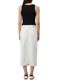 Witte denim midi-rok met een rechte snit, achterzakken en een eenvoudige tailleband, gecombineerd met een zwart mouwloos topje en witte sneakers.