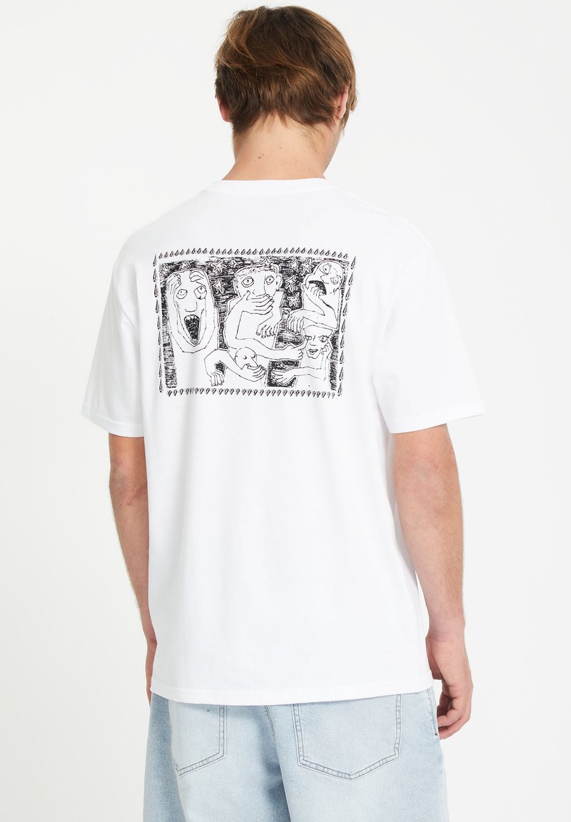 T-shirt en coton blanc avec une illustration graphique noire au dos, présentant des visages abstraits et expressifs encadrés par une bordure décorative.