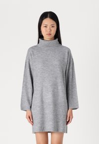 Vestido gris de cuello alto hecho de una suave tela de punto. Presenta mangas largas y un corte relajado, con un dobladillo justo por encima de las rodillas.