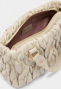 Borsa a tracolla in pelle trapuntata color beige con zip e hardware dorati, dotata di una sola tracolla e un finish liscio e testurizzato. Interno marrone.