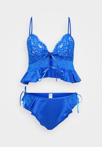 Bikini set u plavoj čipki i satenu, s volanastim peplum gornjim dijelom s podesivim trakama i odgovarajućim donjim dijelom sa bočnim vezicama i čipkastim detaljima.