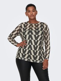 Long-sleeve top with geometric zigzag pattern in black and cream; made from a smooth fabric. Model wears it with black fitted pants.