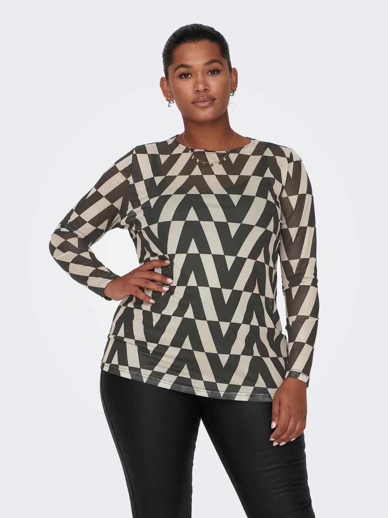 Long-sleeve top with geometric zigzag pattern in black and cream; made from a smooth fabric. Model wears it with black fitted pants.