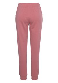Lichtroze sweatpants met een elastische tailleband, smal model en geribde boorden bij de enkels. Gemaakt van zachte, comfortabele stof.