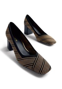 Chaussures à talons hauts rayées noir et or, avec un bout carré, une tige en tissu et un talon bloc. Texture lisse avec un léger brillant.