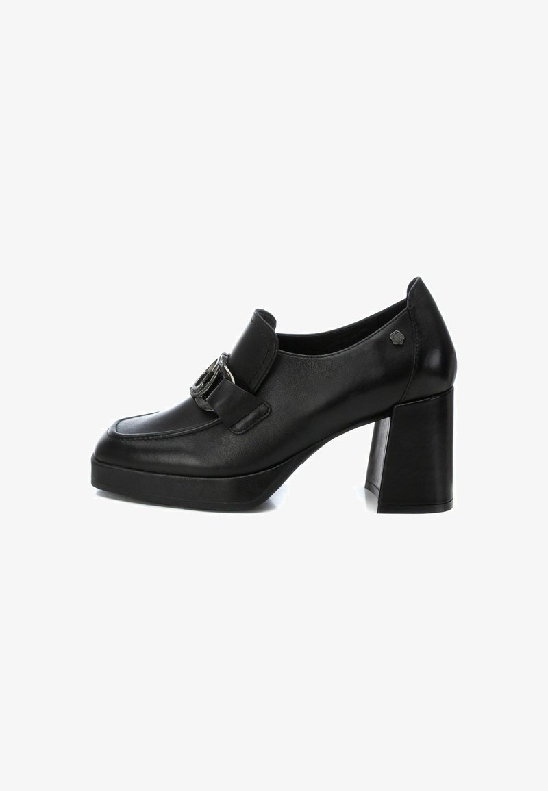 Zapatos de tacón alto de cuero negro con puntera redondeada, panel frontal plano, hebilla decorativa y tacón ancho tipo bloque. Superficie texturizada.