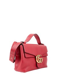 Sac à main en cuir rouge avec large bandoulière et fermoir double G doré sur le rabat avant, présenté sur fond blanc.