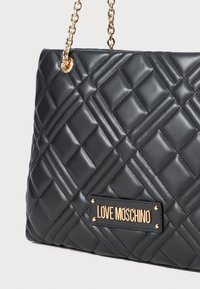 Schwarze gesteppte Lederhandtasche mit einem goldenen Kettenriemen und einer goldenen Logoplatte mit dem Text "LOVE MOSCHINO" auf der Vorderseite.