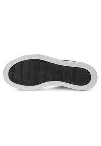 Black rubber shoe sole with a textured grip pattern. Features white edges, horizontal grooves, and a logo detail near the heel.