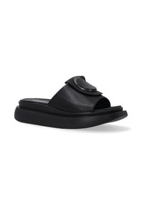 Sorte slip-on sandaler har et perforeret design og en rund dekorerende detalje på remmen, sat mod en hvid baggrund.