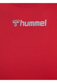 Rode sportshirt van gestructureerde stof met een ronde hals. Heeft een grijs "hummel" logo op de bovenlinkerzijde.