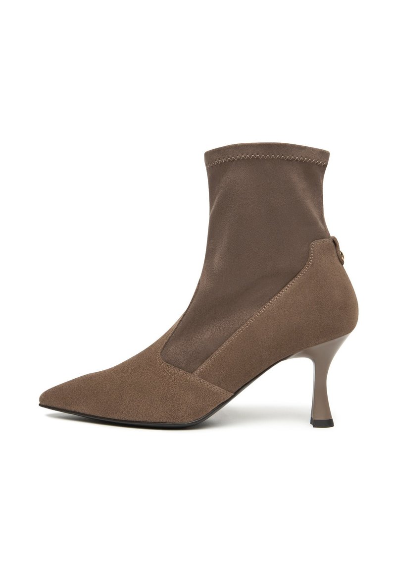 Stivale alla caviglia marrone con punta affusolata, in suede e tessuto liscio, con una tomaia aderente simile a una calza e un tacco alto e sottile. Dettagli di cucitura sottili.