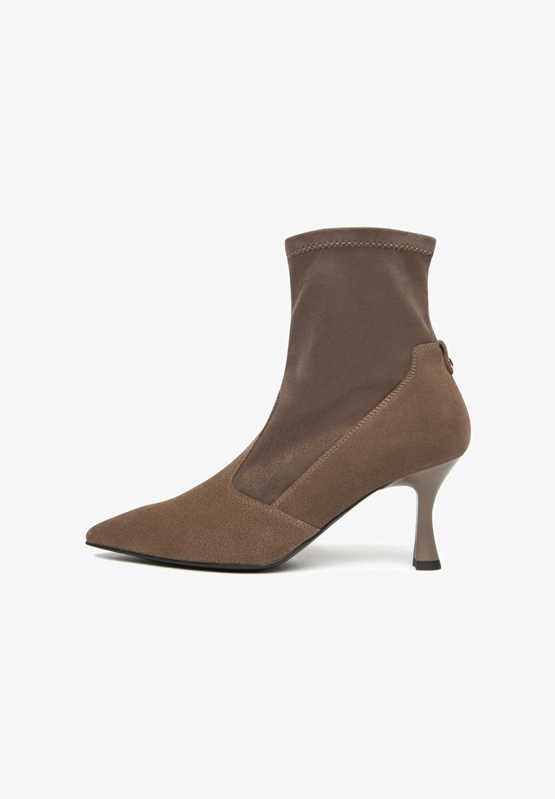 Brauner Knöchelstiefel mit spitzer Zehe, aus Wildleder und glattem Stoff, einer enganliegenden Sockenoberseite und einem schlanken hohen Absatz. Subtile Steppnähte.