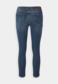 Vaqueros skinny de denim azul oscuro. Presenta una cintura alta, bolsillos traseros curvados y costuras sutiles. Etiqueta en la parte trasera con el nombre de la marca.