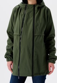 Grön vattentålig jacka med huva, framtill dragkedja, elastiska muddar och sidofickor. Slät yta med en avslappnad passform.