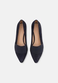 Navy blue suede pointed-toe shoes with a textured elastic band across the instep, featuring a smooth inner lining and slim design.