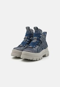 Baskets montantes en denim bleu avec semelles en caoutchouc gris. Comprend de lacets épais, des semelles crantées et un branding marqué sur les languettes.