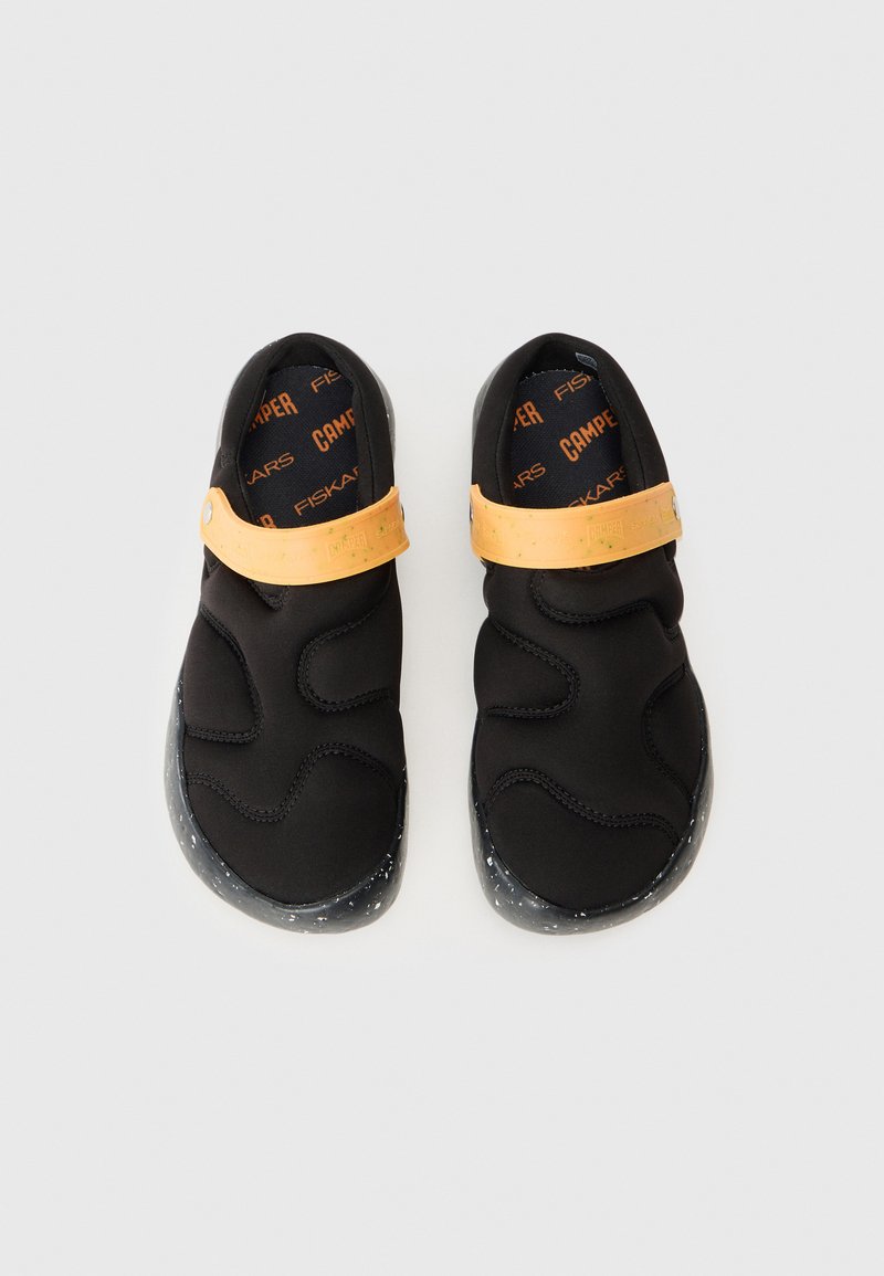 Bottes noires à enfiler avec une tige en néoprène texturé, une sangle en caoutchouc orange et une semelle extérieure noire mouchetée. Dotées d'un rembourrage doux et d'un design flexible.