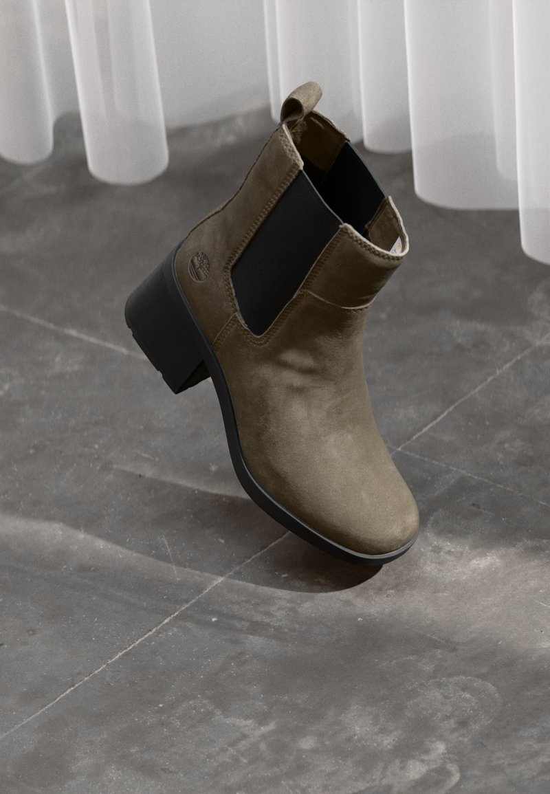 Bottines noir olive en suède, avec des panneaux latéraux en élasthanne noirs, un bout arrondi et un petit talon carré.