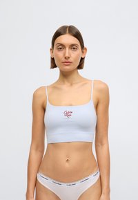 Φωτεινό γαλάζιο, εφαρμοστό bralette με λεπτές τιράντες και κόκκινο λογότυπο "Calvin Klein" μπροστά. Λείο ύφασμα με αδιάκοπο σχέδιο.