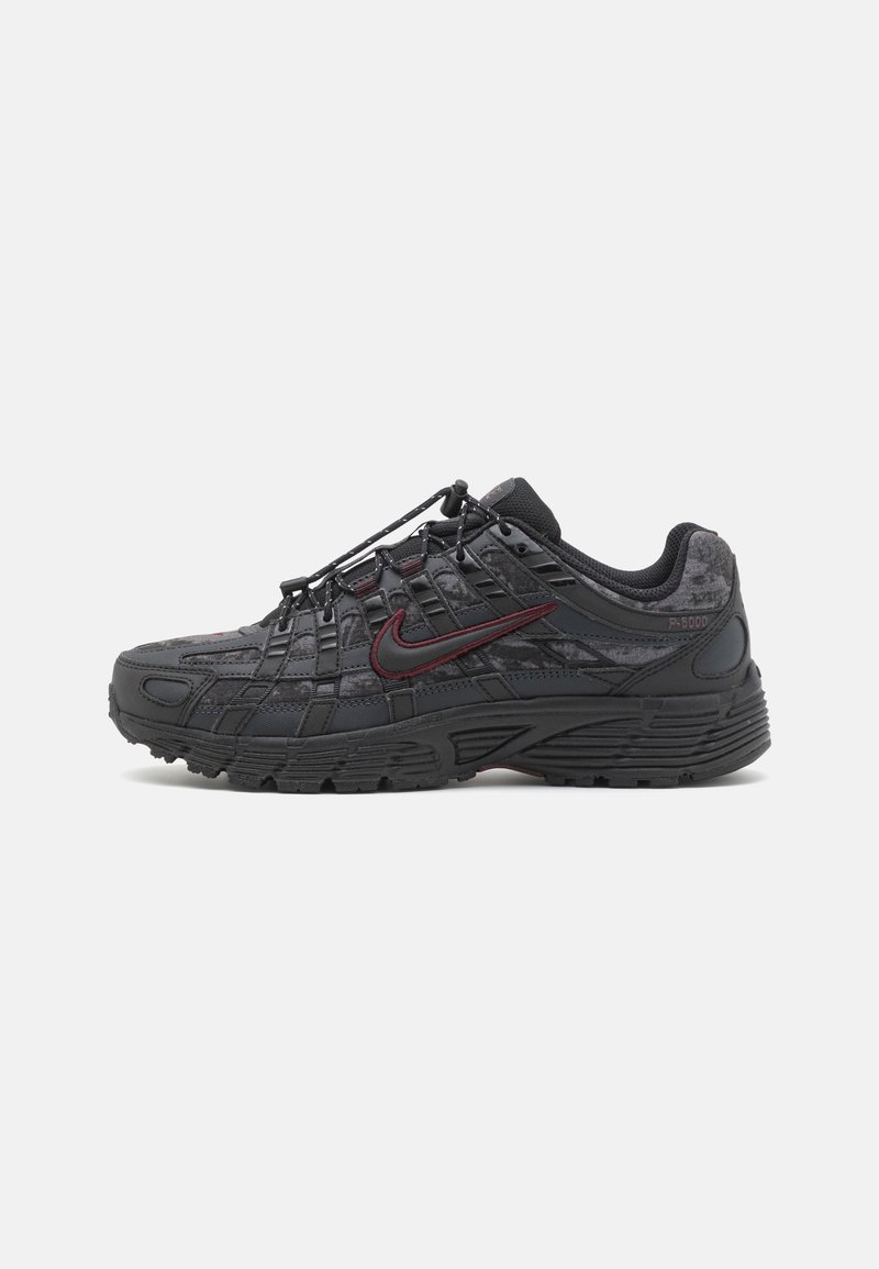 Sapatos atléticos pretos com um cabedal texturizado, sistema de atacadores integrado e um detalhe da swoosh da Nike em bordô. Sola de borracha grossa para tração.