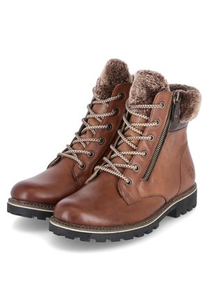 Bottines en cuir marron avec doublure en fausse fourrure, bout rond, semelle en caoutchouc noir épaisse et fermeture éclair latérale décorative avec accent métallique.