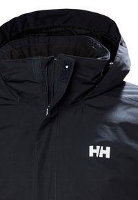 Zwarte waterdichte jas met een hoge kraag, voorrits en klittenbandsluiting. Heeft een opvallend wit logo op de borst. Dichte textuur.