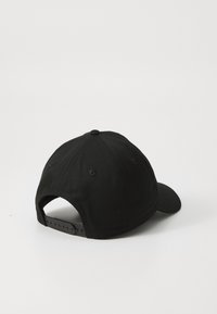 Căciulă de baseball neagră cu margine curbată și închidere ajustabilă tip snapback. Fabricată dintr-un material textil cu o textură netedă și fără logo-uri vizibile.