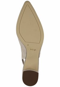 Chaussure à talons hauts en daim beige clair avec un bout pointu, dotée d'un talon fermé et d'un détail découpé sur le côté. Semelle en caoutchouc lisse avec une légère nervure.
