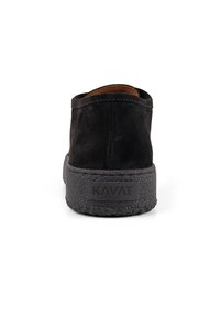 Black suede shoe with a textured rubber sole, featuring a minimalist design and a brown leather lining, labeled with "KAVAT" on the heel.