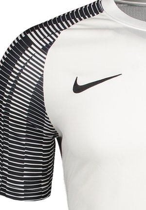 Nike Sportshirt in Weiß mit strukturierten, schwarzen Streifen an den halben Ärmeln. Verfügt über ein schwarzes Nike-Logo auf der oberen Brust. Glatte Stoffoberfläche.