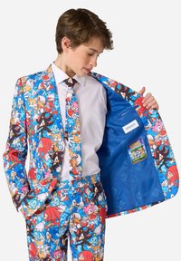 Costume coloré en tissu représentant des personnages de Sonic le Hérisson. L'intérieur est bleu avec une étiquette et une poche pour cartes affichant la couverture d'un jeu.