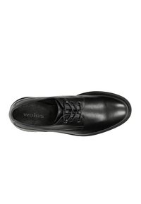 Scarpa elegante in pelle nera con punta tonda, sei occhielli per i lacci, superficie testurizzata e suola liscia; logo "wojas" all'interno della scarpa.
