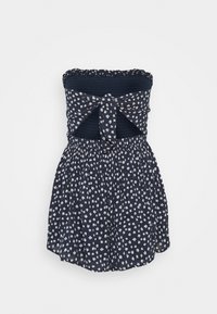 Marinblå strapless klänning med vit blommönster, smockad bodice, knyt i midjan och utsvängd kjol med rynkad textur.