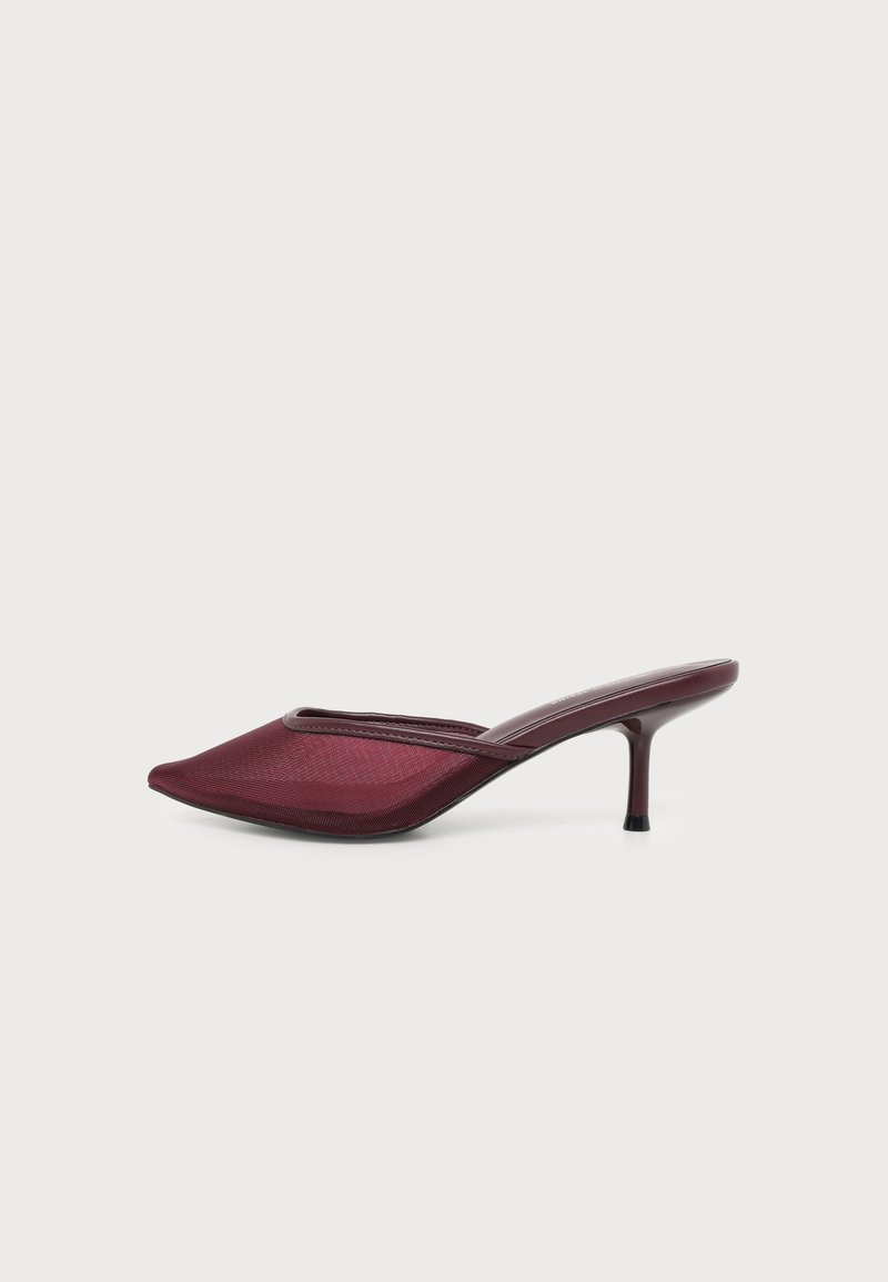 Chaussure mule bordeaux à bout pointu avec un petit talon stiletto et un matériau supérieur en maille sur fond blanc.