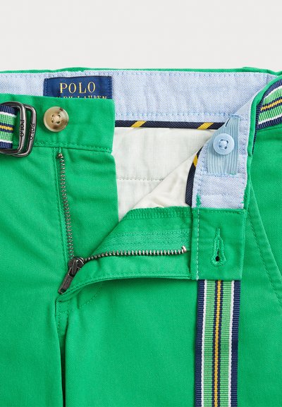 Calças de algodão verdes com fecho de correr, fecho de botão e detalhes na cintura com riscas. Interior forrado com um tecido leve.