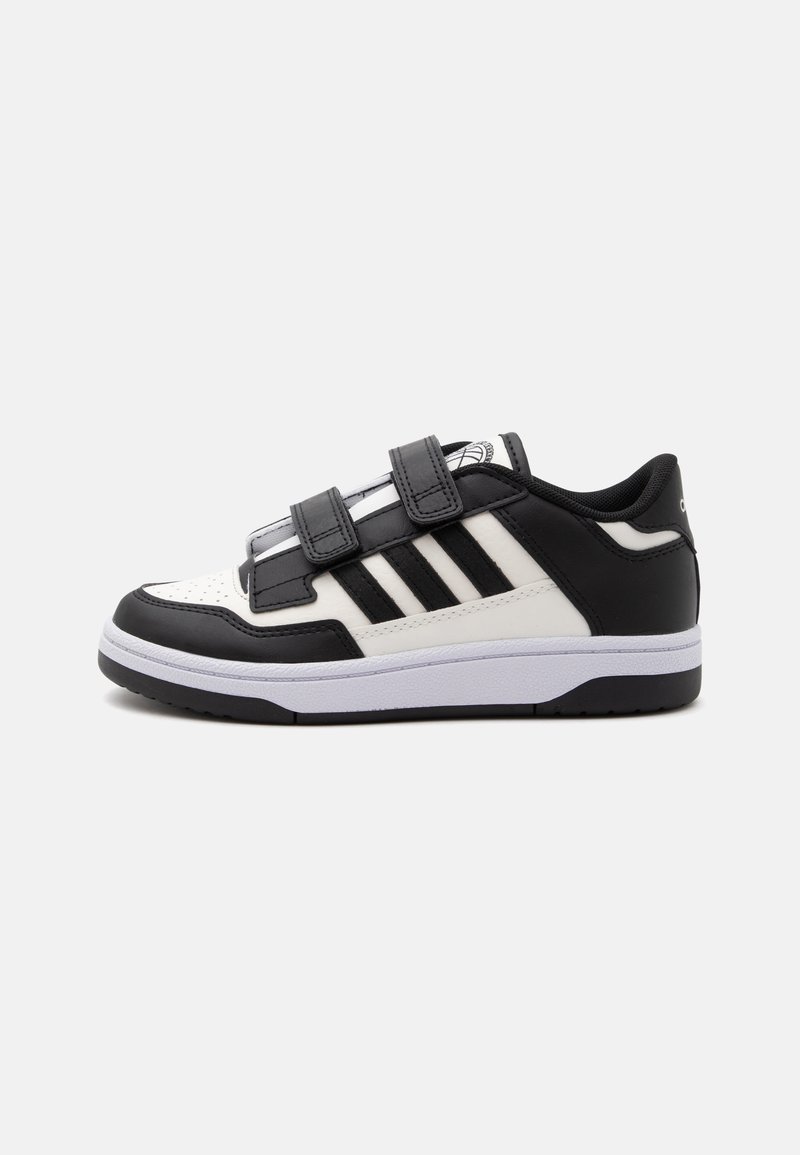 Μαύρο-λευκό sneaker χαμηλού ύψους με τρεις μαύρες ρίγες και δύο μαύρα λουράκια βέλκρο, από την εξωτερική πλευρά.