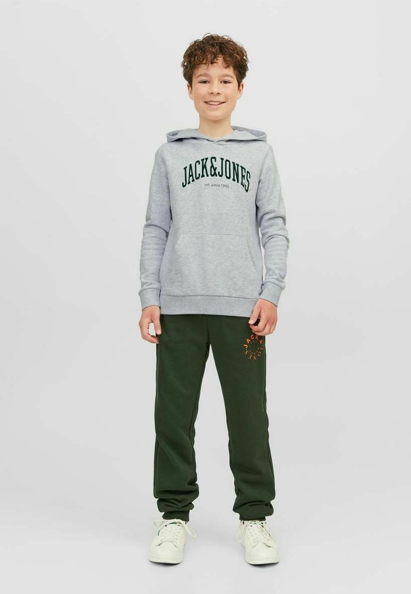 Sudadera gris con el texto negro "JACK&JONES"; joggers verdes con una marca naranja; zapatillas blancas; ajuste relajado, tejido suave.