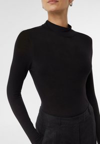 Zwarte lange mouwen turtleneck met een strakke pasvorm. Zachte, rekbare stof, gladde textuur en minimale naden voor een gestroomlijnd uiterlijk.