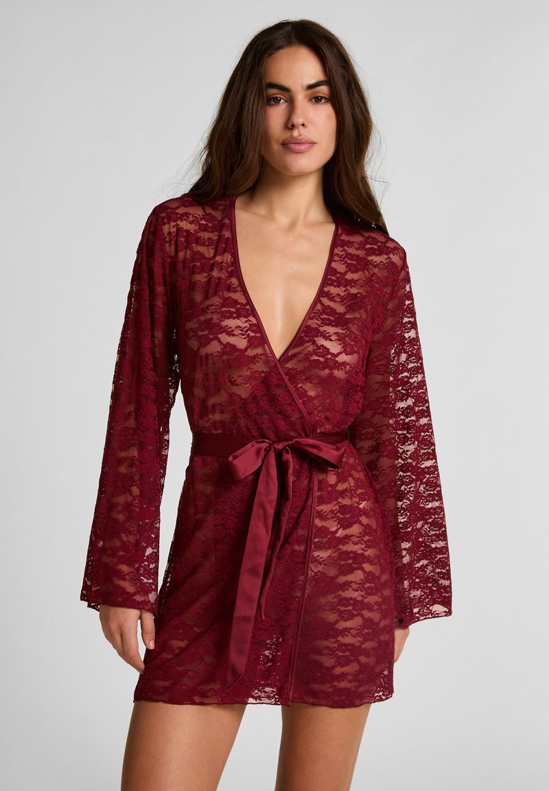 Μπορντό δαντελωτό ρόμπα με μακριά μανίκια, βαθύ V ντεκολτέ και σατέν ζώνη στη μέση. Διαθέτει λεπτό floral σχέδιο και διαφανή υφή.