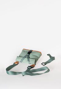 Borsa a rotolo verde con accenti marroni, cinture regolabili e fibbia. Texture liscia e design compatto adatto per l'uso quotidiano.