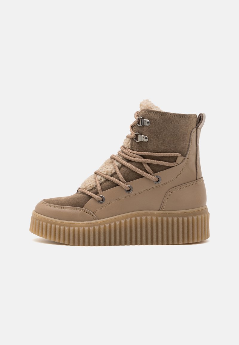 Τα χιαστί μποτάκια σε ταμπά απόχρωση διαθέτουν μαλακό κολάρο, υφασμάτινη σόλα και αντίθετο σχέδιο κορδονιών. Έχουν απαλή, χνουδωτή επένδυση στο εσωτερικό για ζεστασιά.